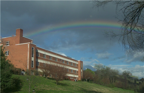 A picture of Lucy Addison Middle School with a rainbow over it right after a rainstorm